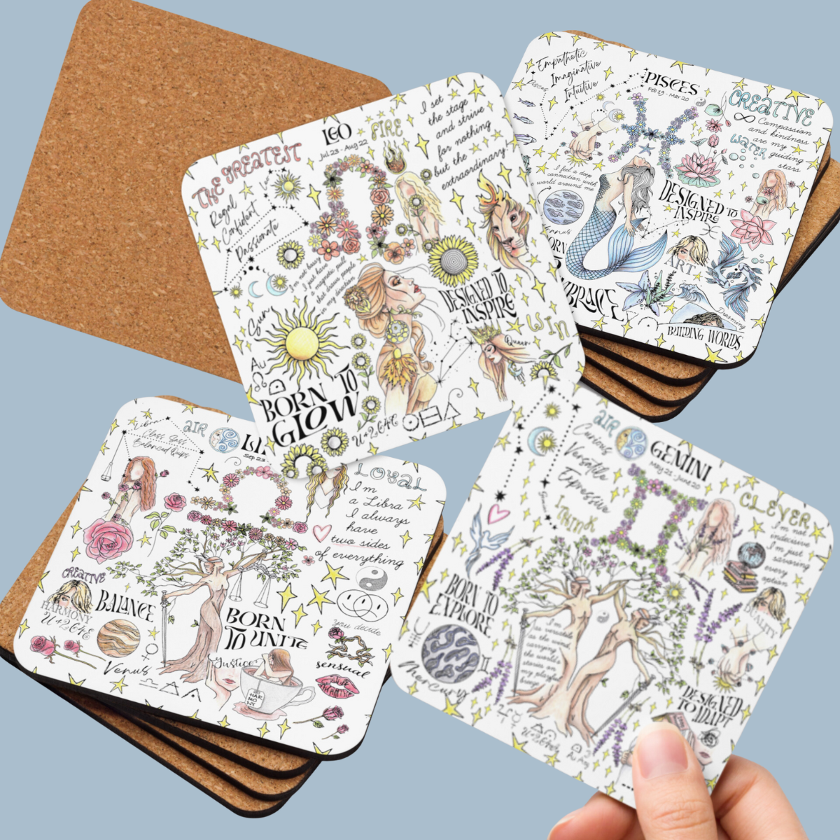 a hand holding four coasters with different designs on them